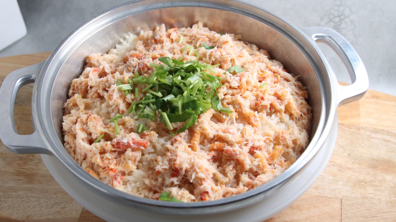 ズワイガニのほぐし身と三つ葉をのせたカニの炊き込みご飯