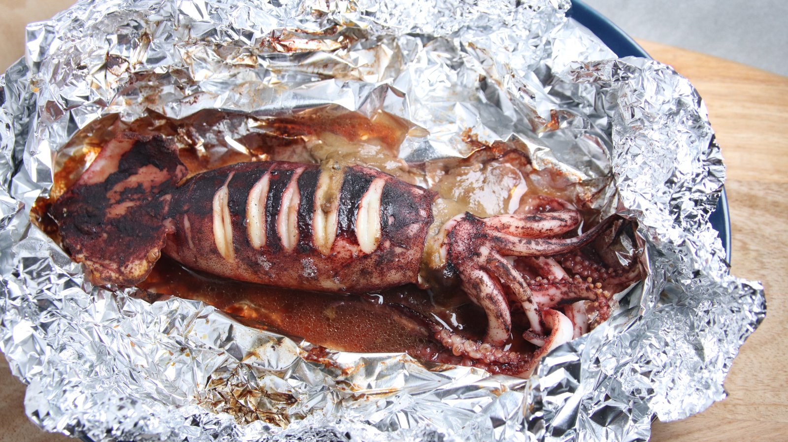 スルメイカの肝を使った丸焼き。アルミホイルで蒸し焼きにした胴とゲソ